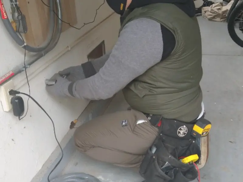Electrician performing outlet wiring in a Linton Hall garage